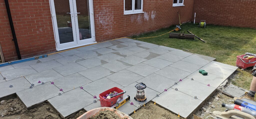 Porcelain patio being laid behind a house