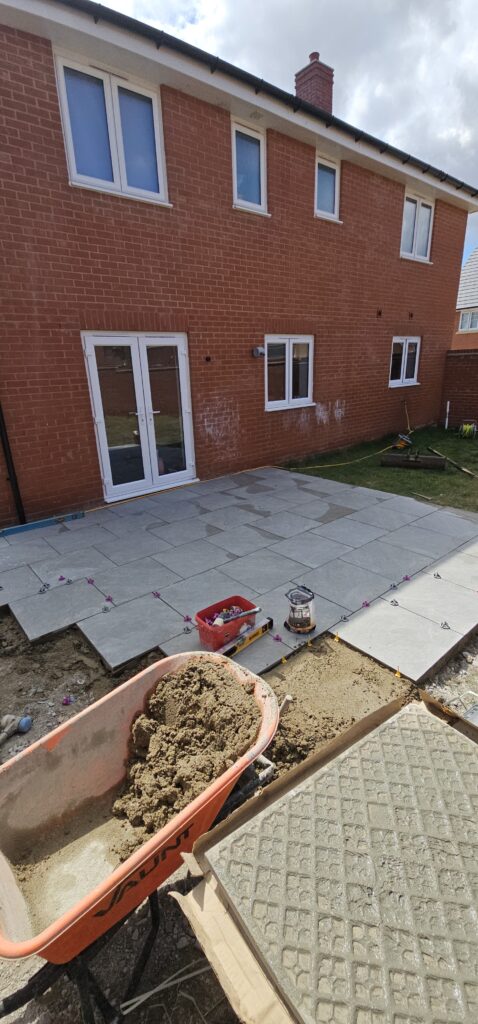 Porcelain patio being laid behind a house