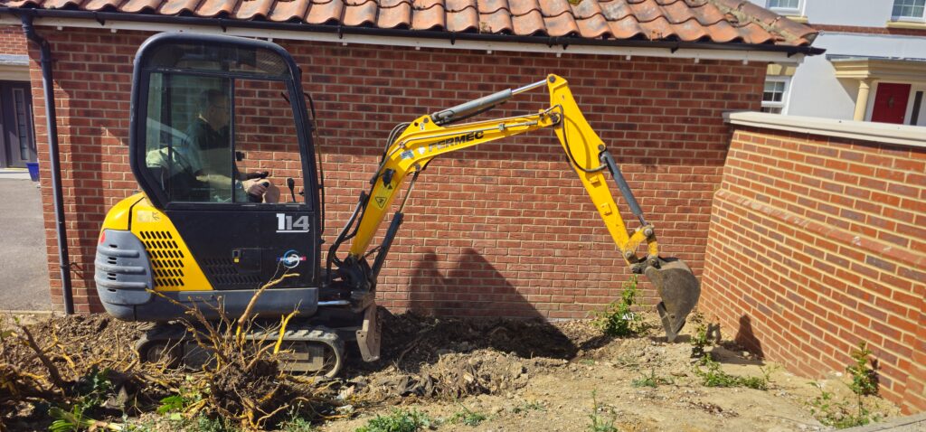 Mini digger clearing a front garden ready for landscaping
