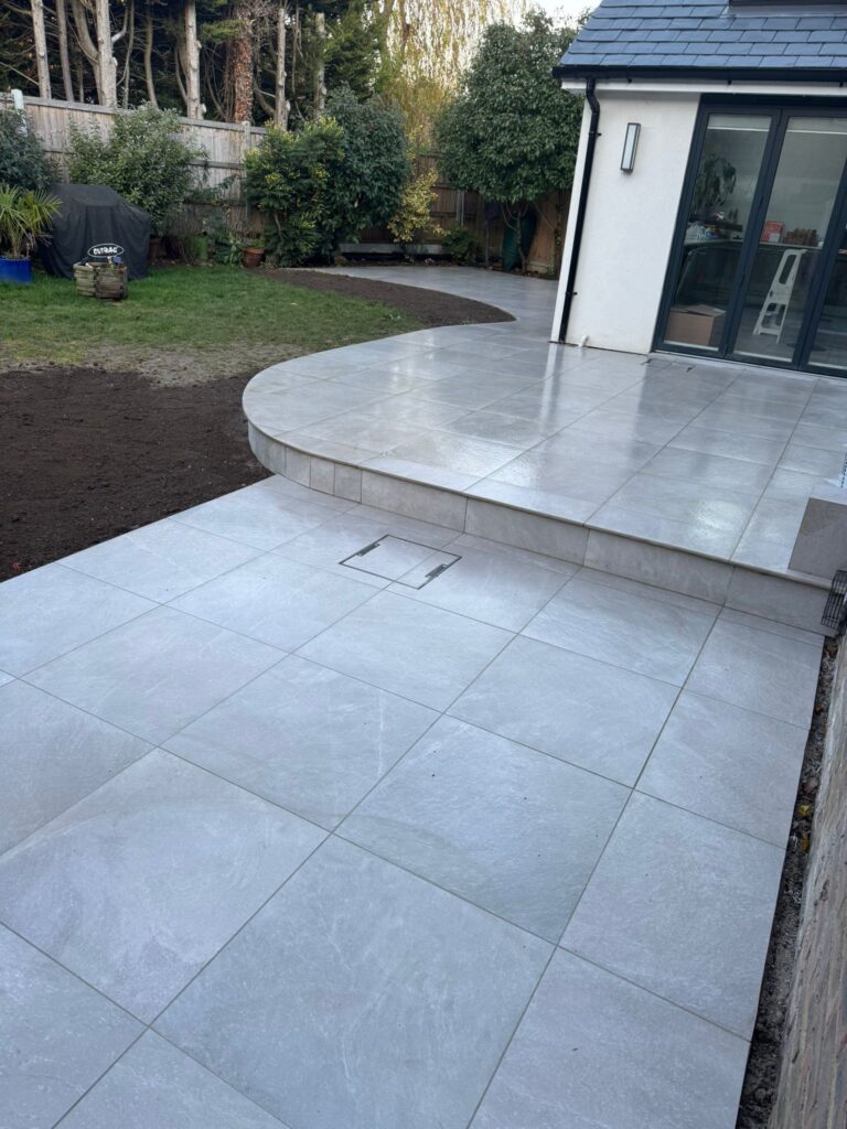 Curved porcelain step leading onto a new patio